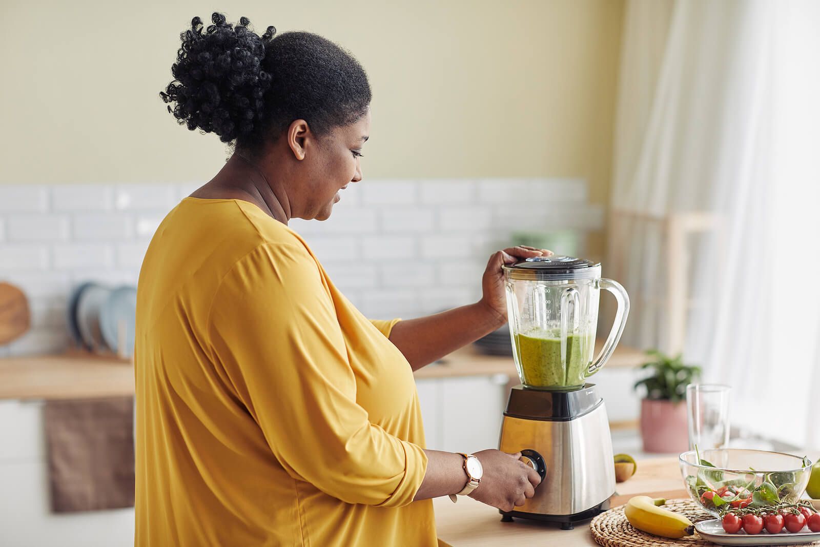 A woman making a smoothie in the kitchen. Discover the difference between a dietician & a nutritionist by exploring our blog here. Call today to get started with nutritional counseling in Asheville, NC.