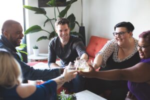 A group of friends cheering their drinks together in the middle. Representing how medical nutrition therapy in Raleigh, NC can help with chronic pain, diabetes management & more. Contact us today to get started with a dietitian. 