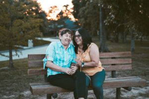 A mother & daughter sitting closely together on a wooden park bench. Nutrition therapy in Raleigh, NC can support your journey in anorexia recovery. Read our blog here for more information!