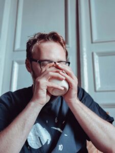 A man holding his cup with both hands & drinking from the mug. Our registered dietitians in Raleigh, NC are here to support your recovery. Reach out to us today to get started with nutritional counseling. 