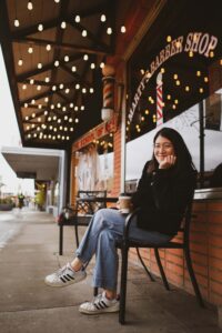 A girl sitting down on a bench outside a cafe. If you're recovering from disordered eating, reach out to our registered dietitians in Raleigh, NC. We can support your recovery journey! 