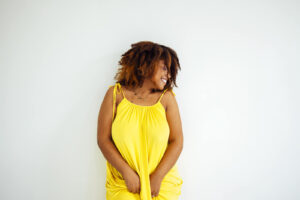 A beautiful woman wearing a yellow dress posing in front of a white background. To discover how nutrition therapy in Raleigh, NC can help you, read our blog here! Our dietitians are here to support you. 