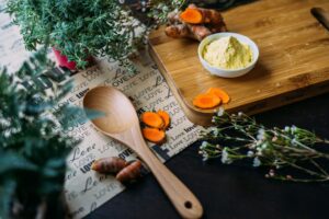 Vegetables & spices on a cutting board displayed with green plants. Our nutritionists in Raleigh, NC are here to support your eating disorder recovery. Get started with our registered dietitians today.