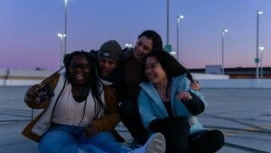 A group of diverse friends hugging & smiling for a photo together. Representing how disordered eating therapy in Raleigh, NC can help you recover from disordered eating & chronic dieting. Call now to begin.