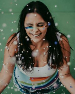 An individual smiling with glitter & sparkles raining down. Read our blog here to learn more about nutrition therapy in Raleigh, NC & how it can help you. Contact us today to start your healing journey. 