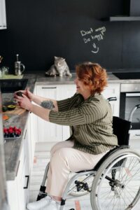 A woman in a wheelchair prepares fresh ingredients in her kitchen, embracing a balanced approach to food through nutrition therapy in Raleigh, NC while receiving compassionate support from binge eating disorder therapy in Asheville, NC to foster a healthier relationship with nourishment.